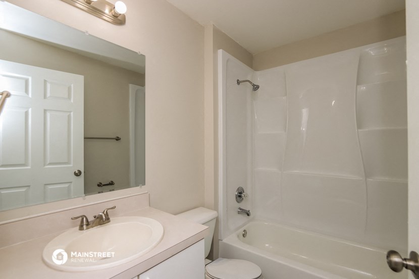 a bathroom with a sink and a shower and a mirror