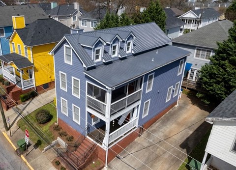 a blue house with a gray roof and a yellow house