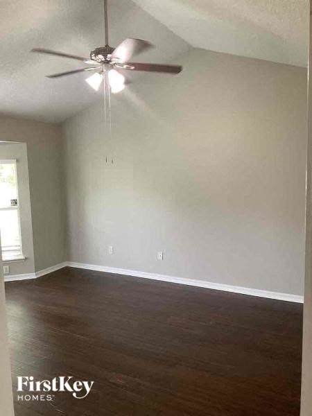 an empty living room with a ceiling fan