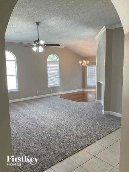an empty living room with a ceiling fan