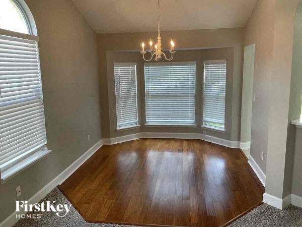 a living room with a wood floor and a chandelier