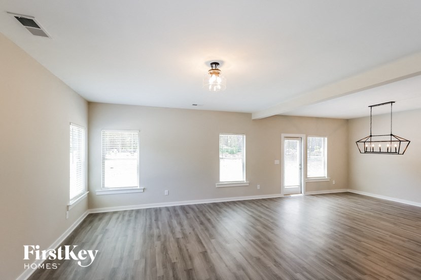 an empty living room with white walls and wood floors