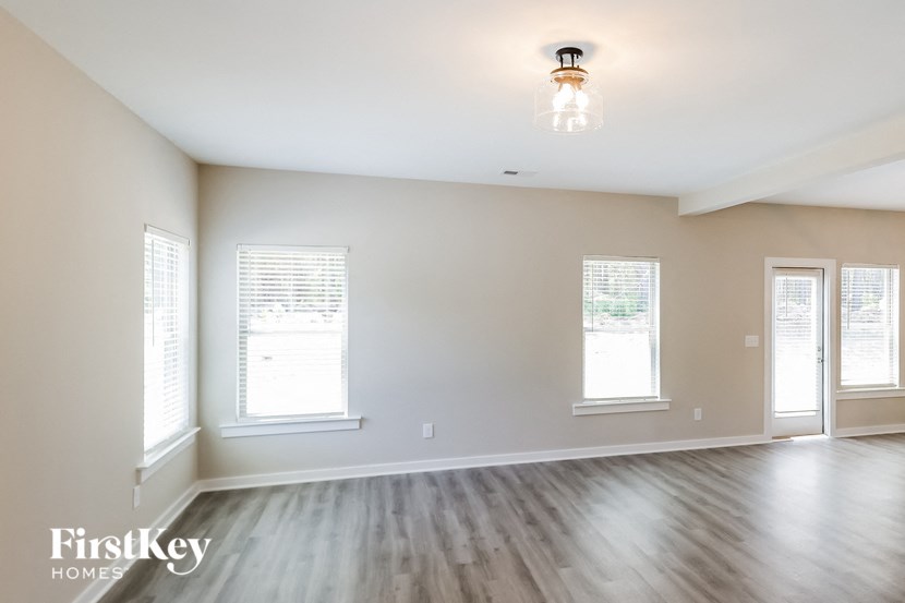 an empty living room with white walls and a wooden floor