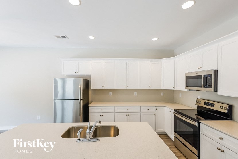 a kitchen with white cabinets and stainless steel appliances