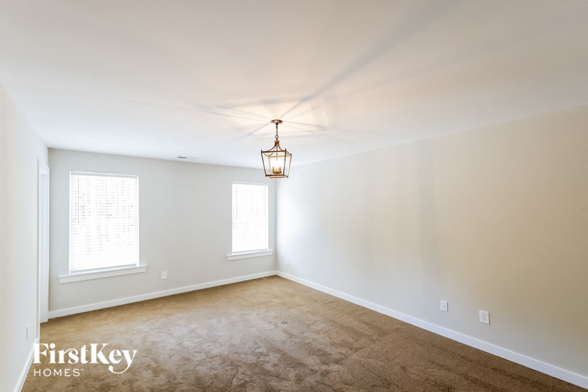 a living room with a carpet and a lamp on the ceiling