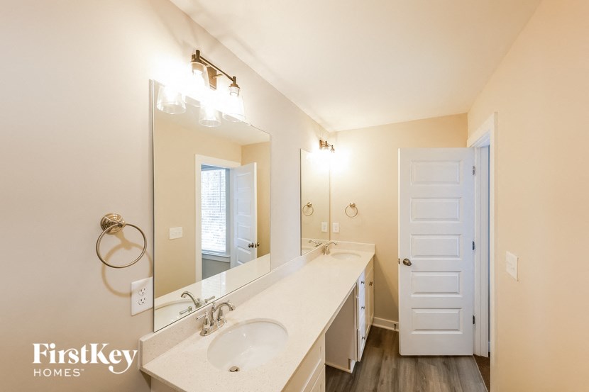 a bathroom with a sink and a mirror and a door