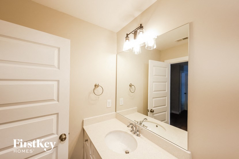 a bathroom with a sink and a mirror and a closet