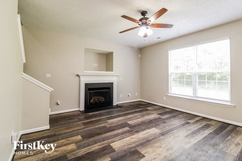 a living room with a fireplace and a ceiling fan