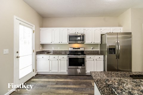 a kitchen with white cabinets and stainless steel appliances