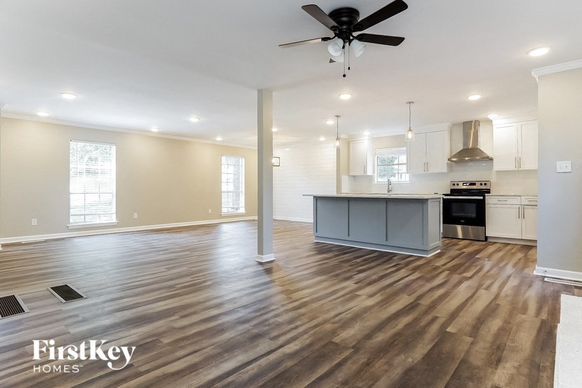 an open kitchen and living room with hardwood floors and a ceiling fan