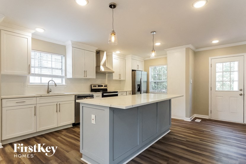 a kitchen with white cabinets and a large island