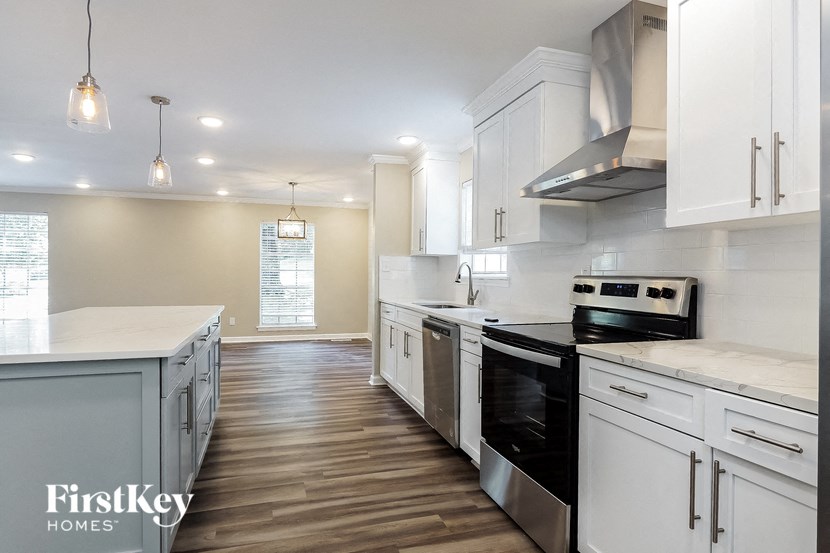 a white kitchen with black appliances and white cabinets