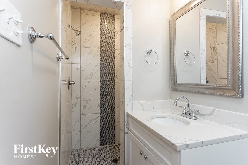 a bathroom with a shower and a sink and a mirror