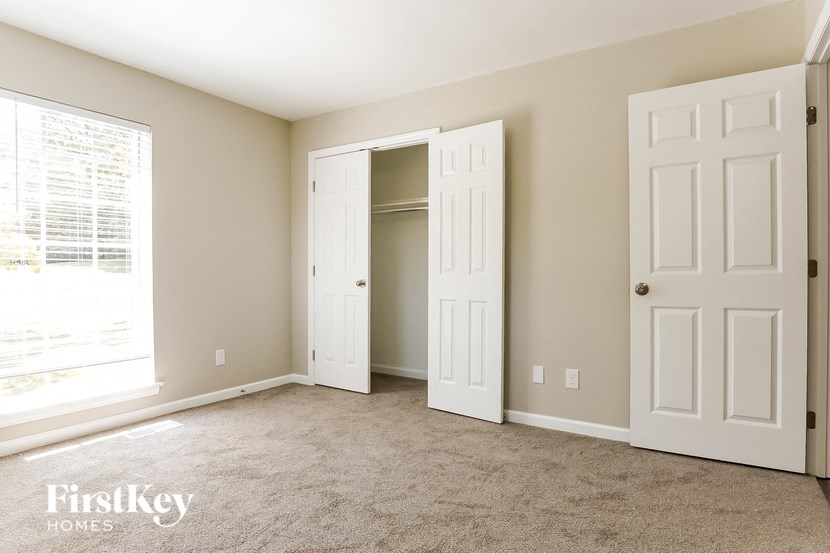 a bedroom with two doors and a closet and a window