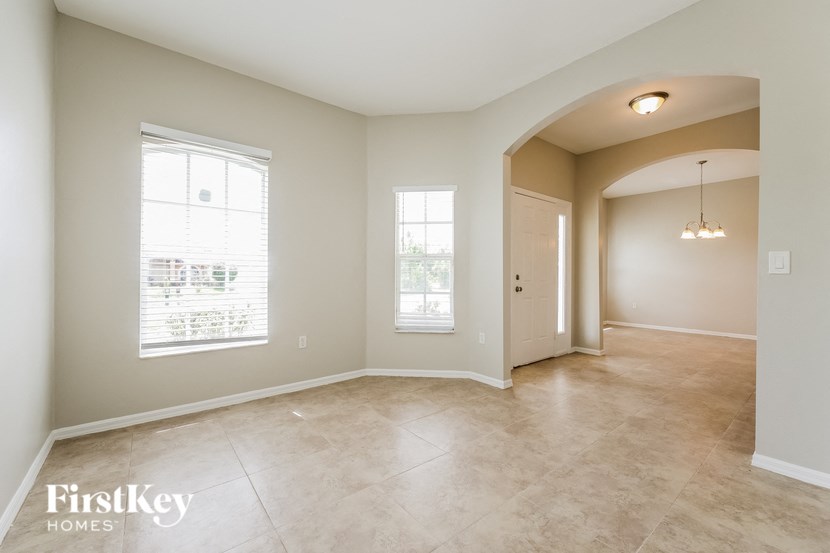 an empty living room with a door and a window