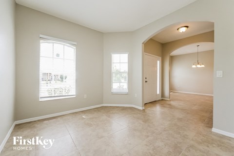 an empty living room with a door and a window