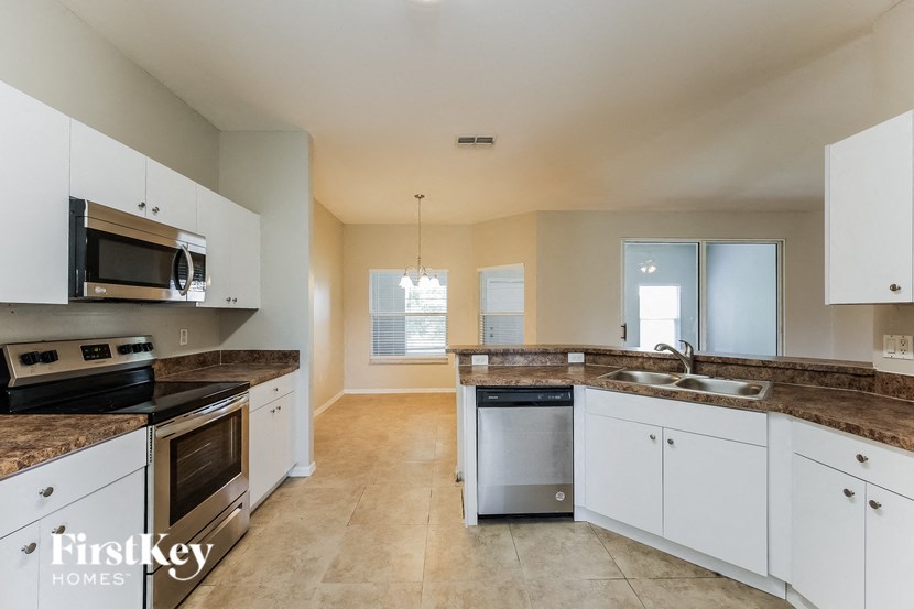 a large kitchen with white cabinets and granite counter tops