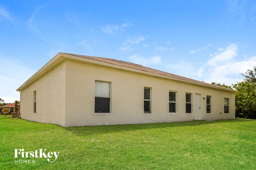 an old white building with a grassy yard in front of it