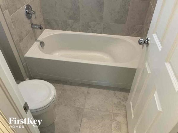 a bathroom with a white toilet and a bath tub