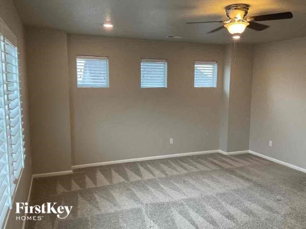 a empty living room with a ceiling fan