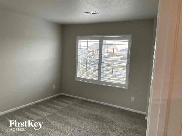 an empty room with a window and a carpet