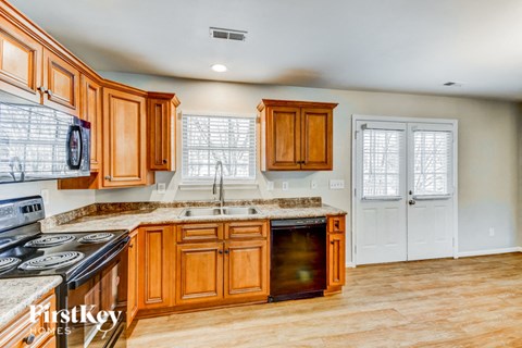 a kitchen with wooden cabinets and a sink and a door