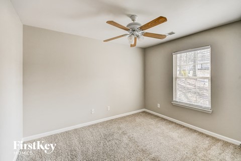 a bedroom with a ceiling fan and a window