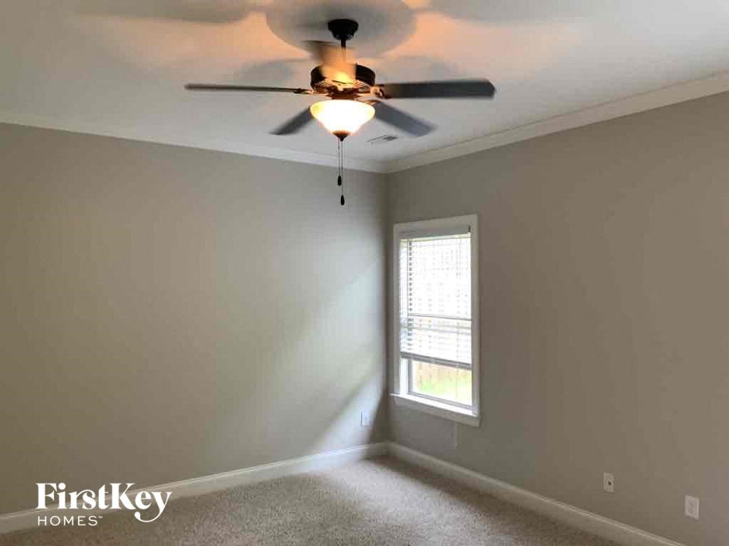 A room with a ceiling fan and a window.
