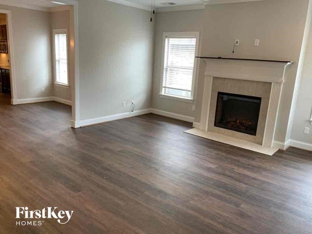 A living room with a fireplace and wood flooring.