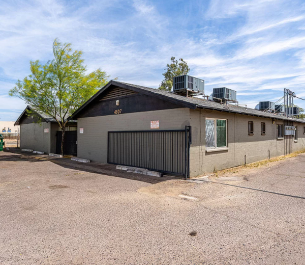a white building with a black roof and a garage