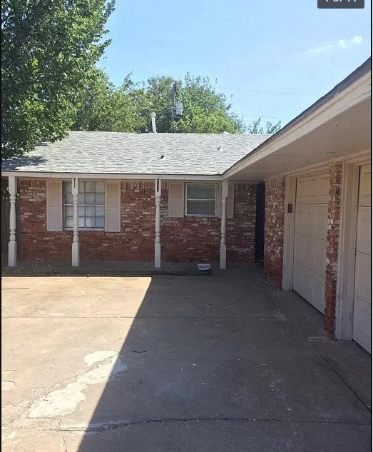 a brick house with a driveway and a white door