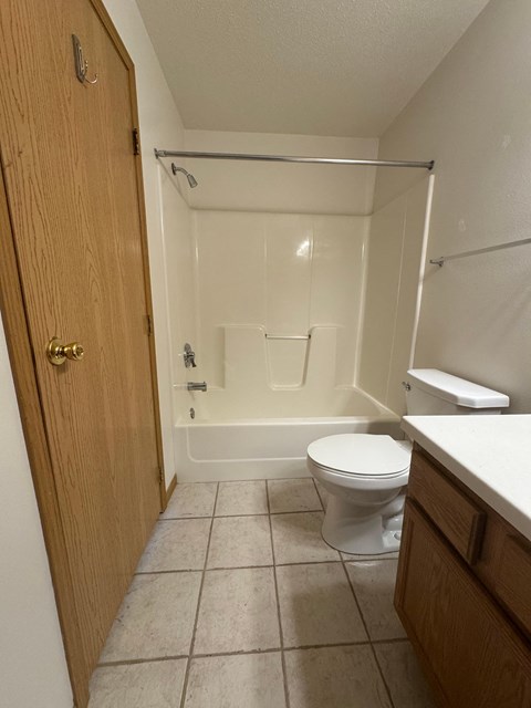 A small bathroom with a toilet, a shower, and a sink.