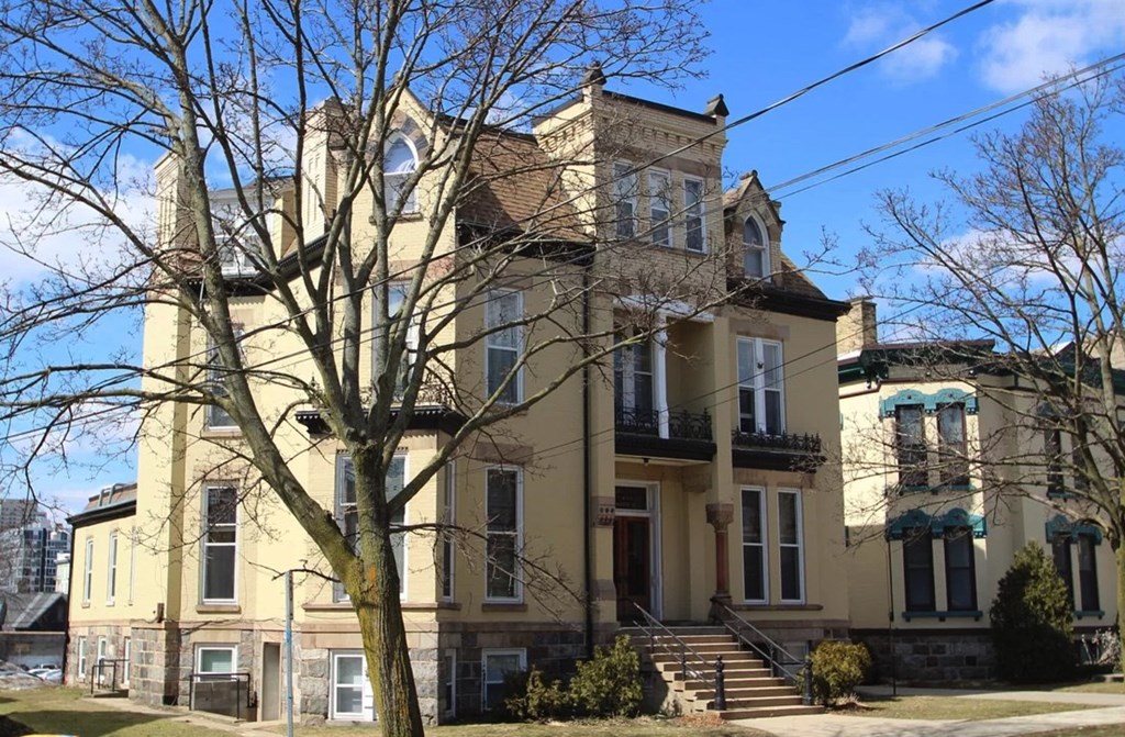 a large yellow house with a tree in front of it