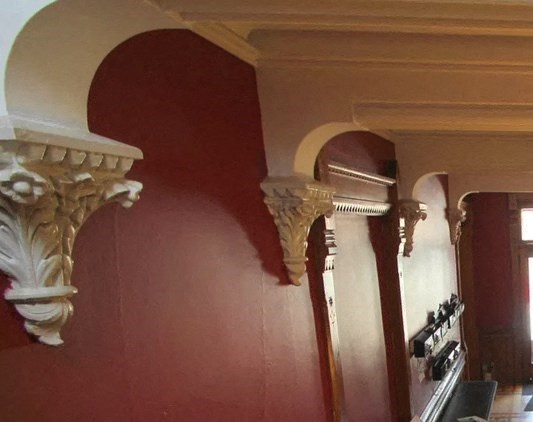 a row of columns in a room with red walls