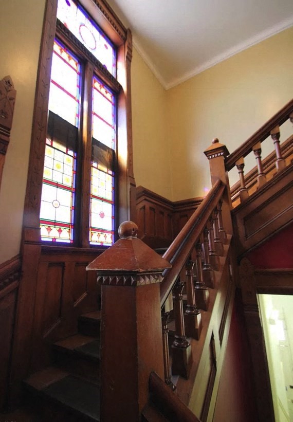 the stairs in a building with stained glass windows