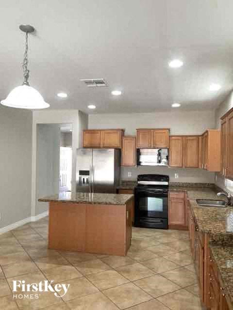 A kitchen with brown cabinets and a granite counter top.