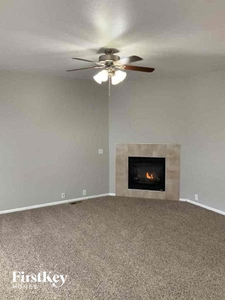 a living room with a ceiling fan and a fireplace