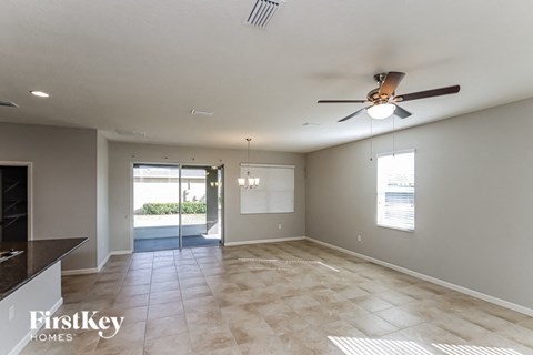 A spacious room with a ceiling fan and tiled floor.