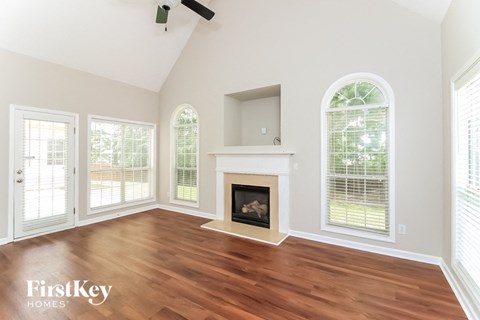 A living room with a fireplace and a tv on the wall.