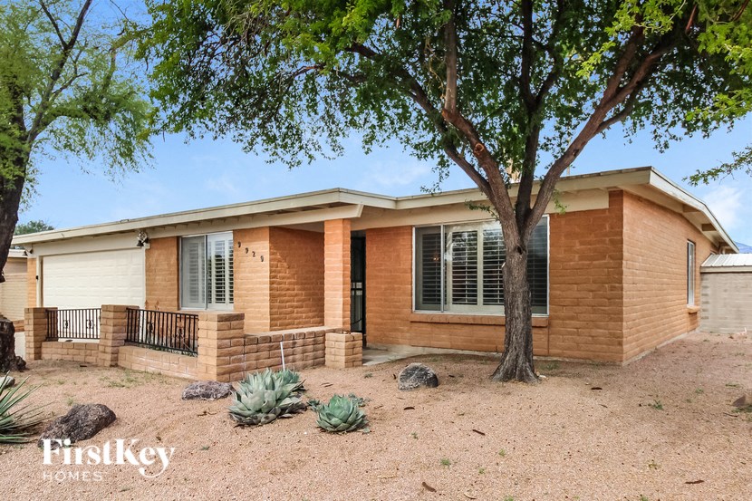 a small brick house with a tree in front of it