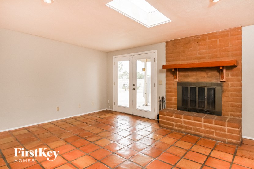 the living room has a brick fireplace and a door to the patio