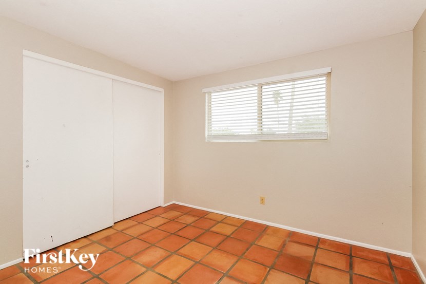 the living room of a home with a tiled floor and a window