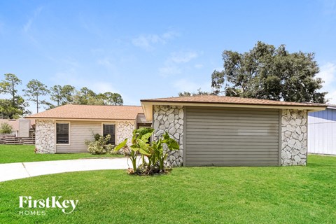 a small house with a yard and a garage