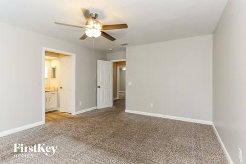 a living room with a ceiling fan and a carpeted floor