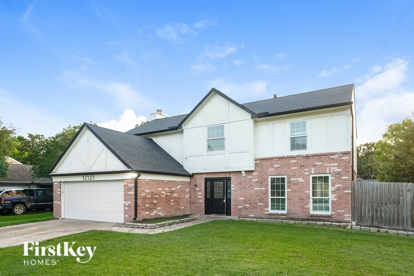 A house with a white garage door and a black door.
