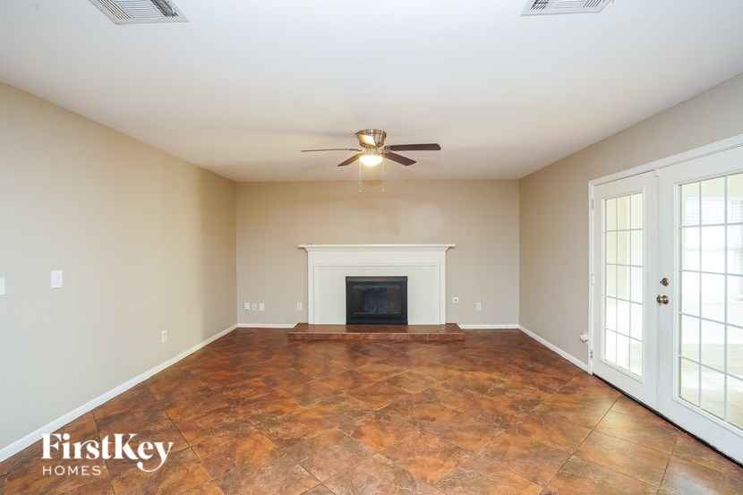 A spacious room with a fireplace and a ceiling fan.