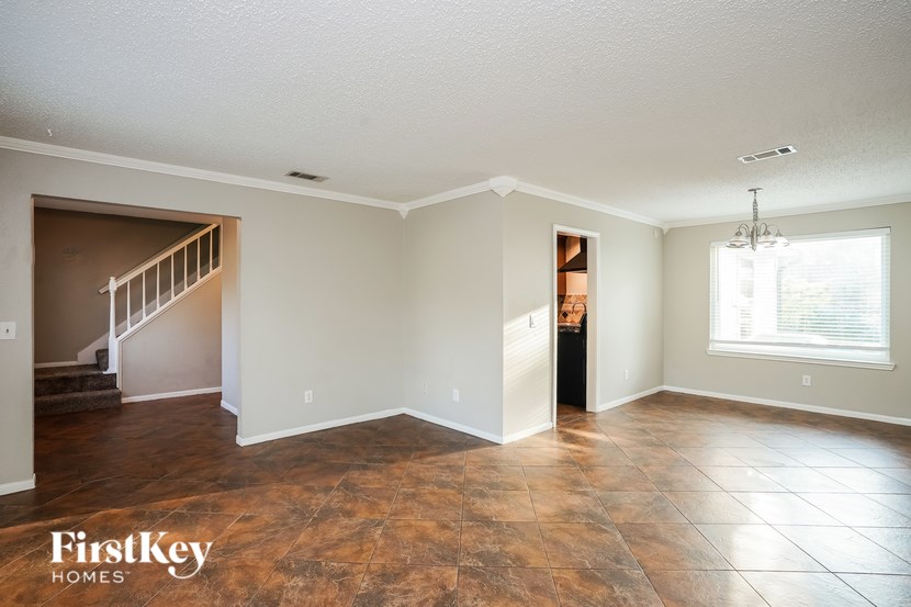 A spacious room with a staircase and a window.