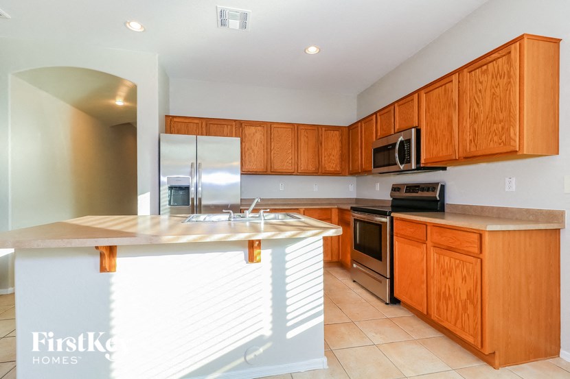 a kitchen with wooden cabinets and a counter top and a sink