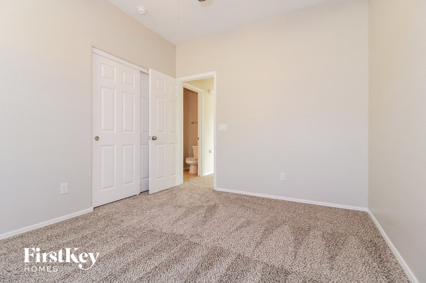 a bedroom with a carpeted floor and white doors