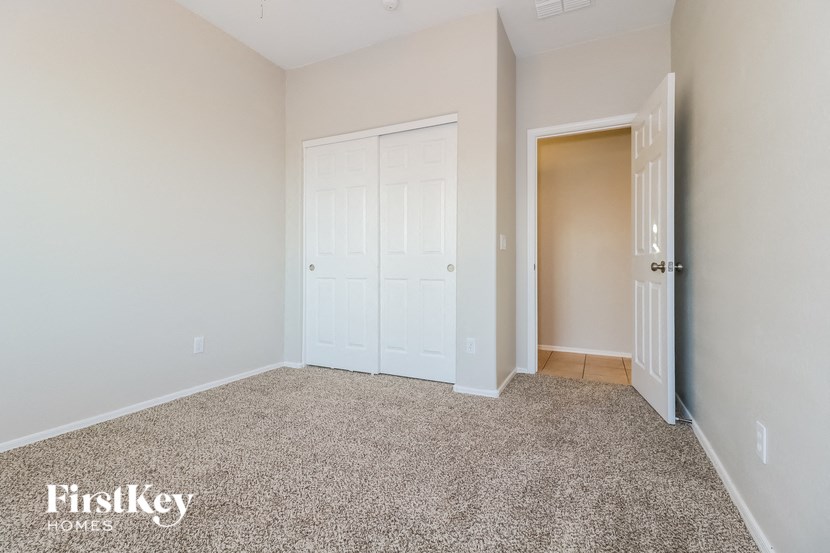 a bedroom with a carpeted floor and a white door